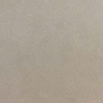 Rugiano rug, aniline cashmere leather, brandy color, mottled texture, warm beige and brown tones, subtle directional grain pattern.